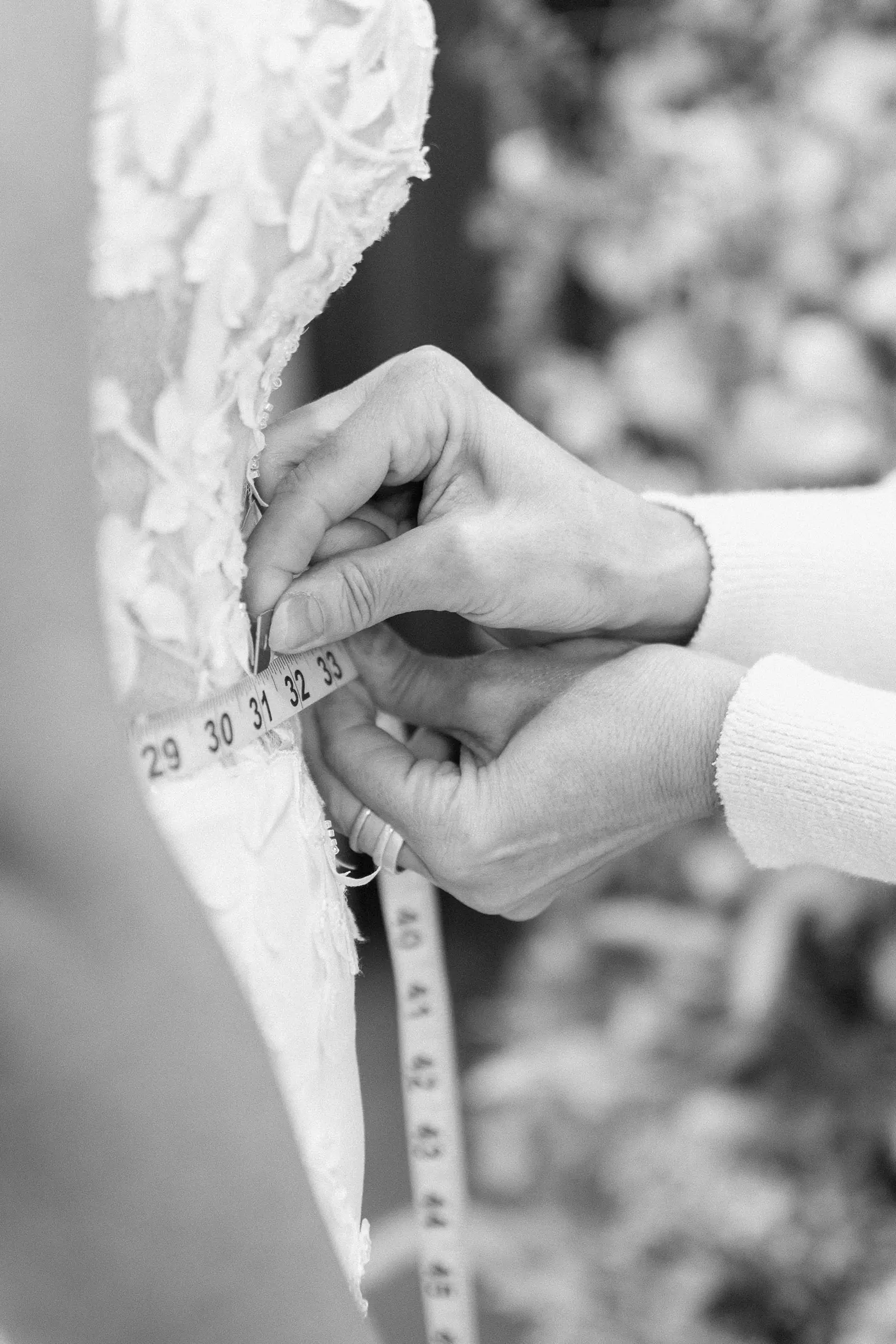 A gown being pinned and measured on the workroom floor