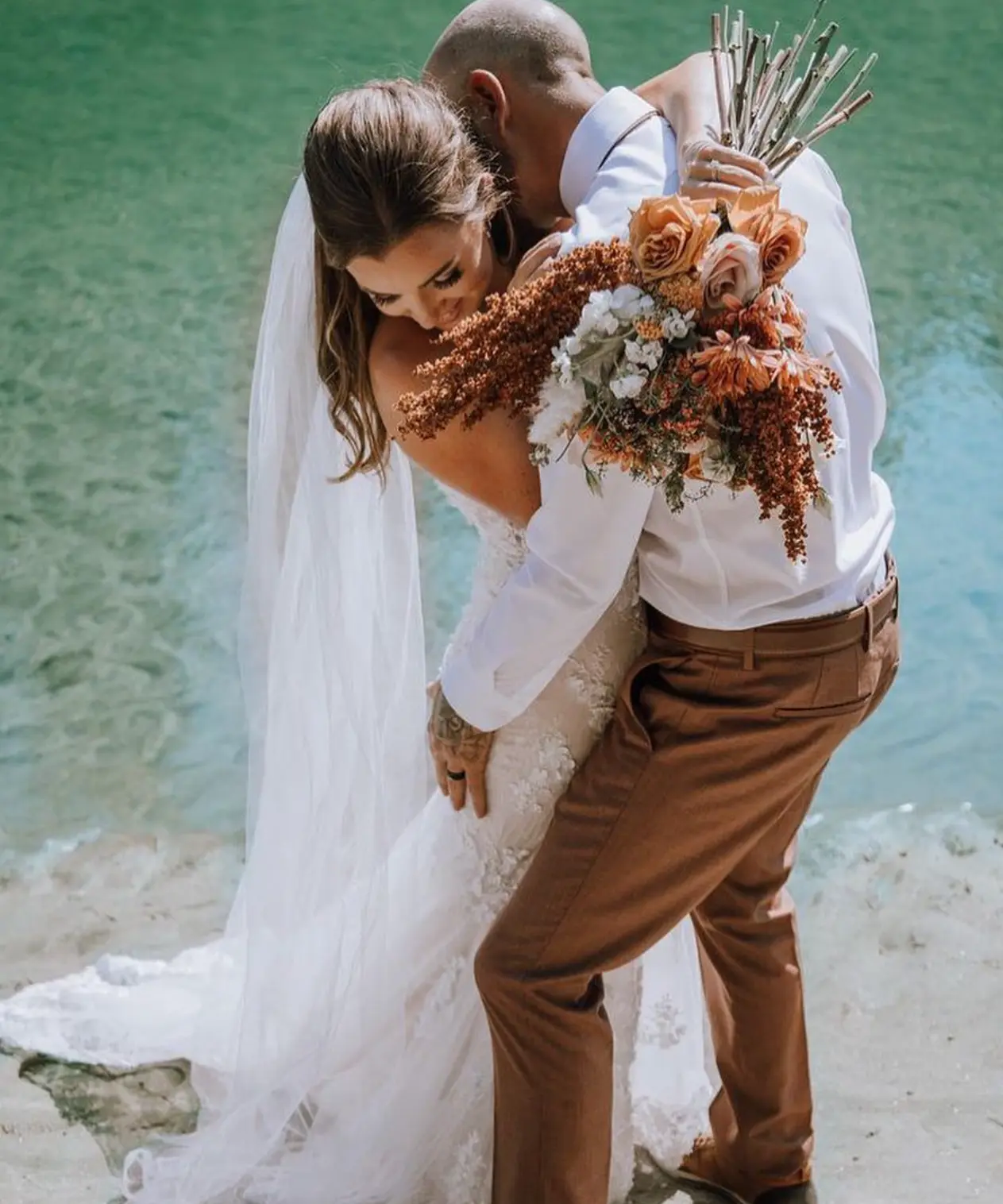 A bride and her husband on the shore of Okanagan Lake after the ceremony